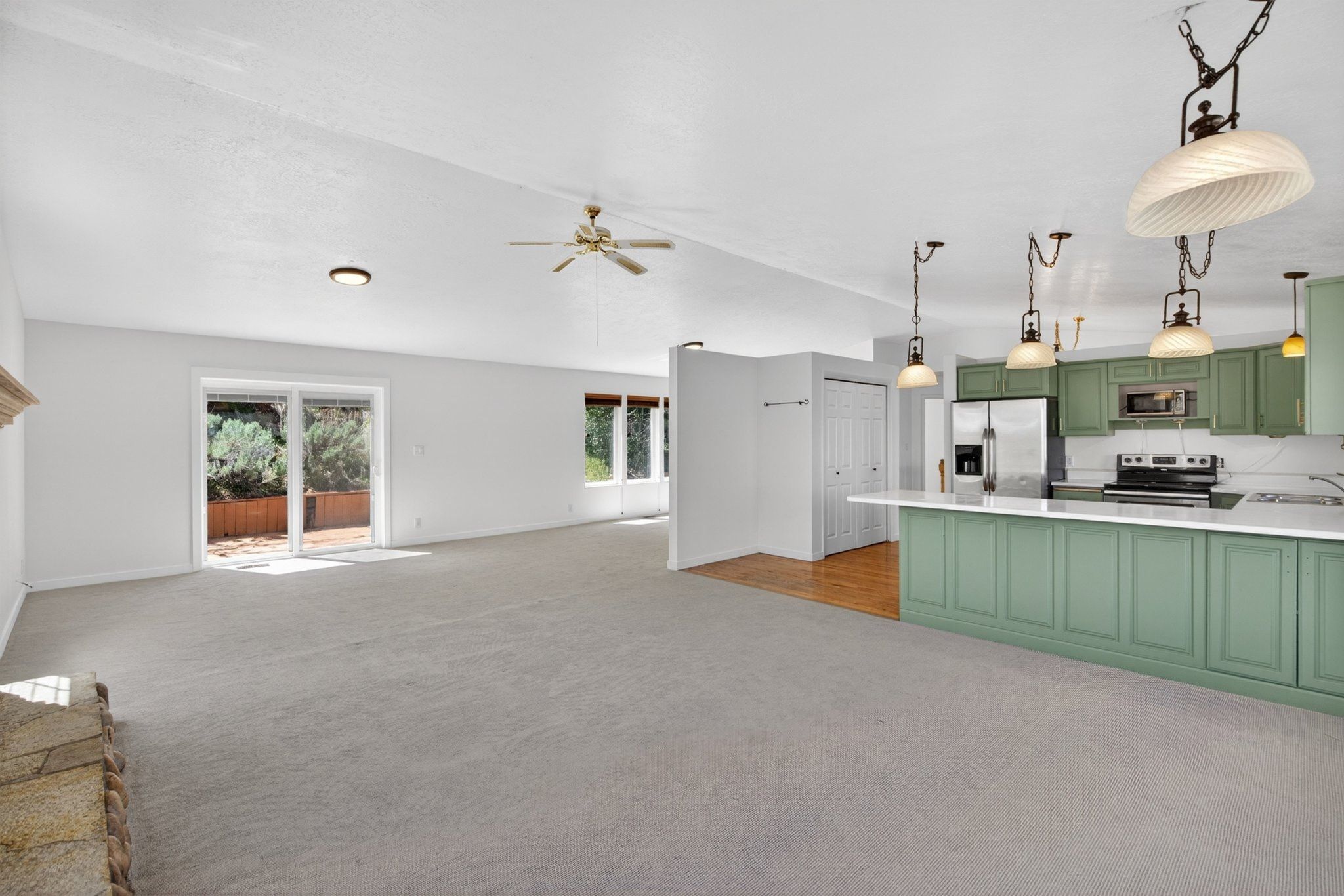 Open concept living area featuring light gray carpeting and white walls