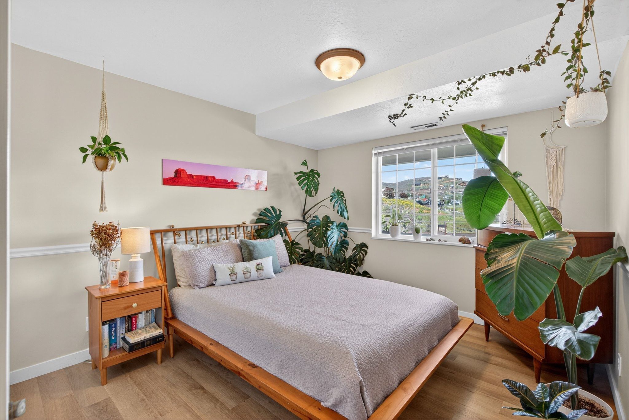 Neutral-toned walls featuring a picture rail molding, ceiling-mounted light fixture, and wood-finish flooring