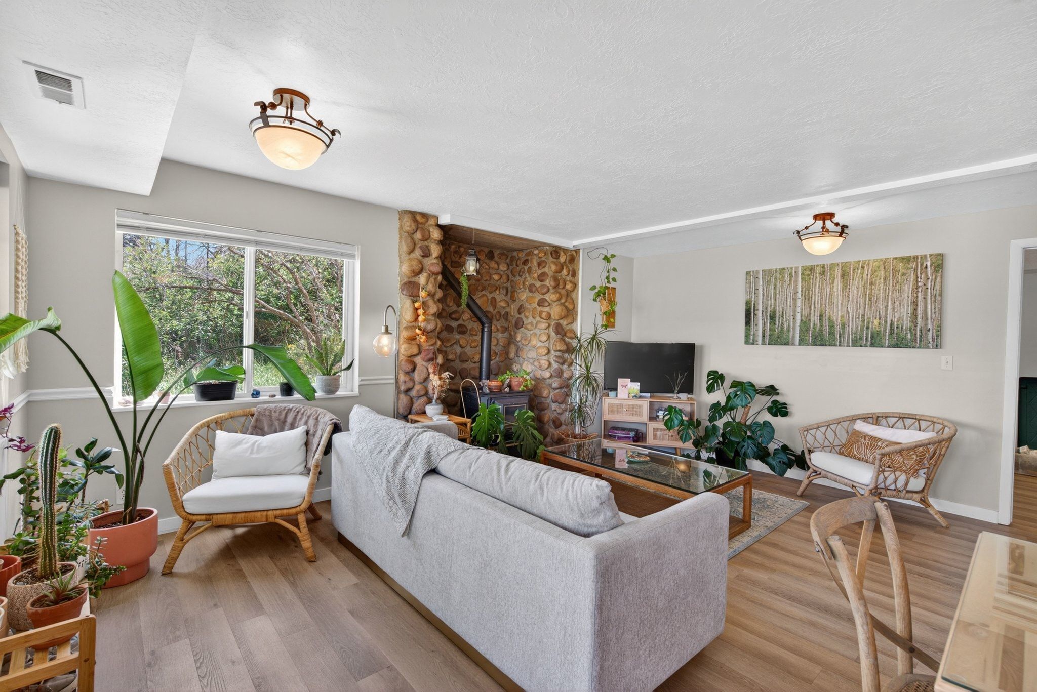 Living area featuring a stone accent wall, wood-finish flooring, and recessed ceiling lighting