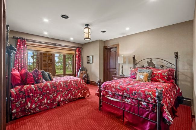 Room featuring a wide window with exterior tree-lined scenery, recessed lighting, a central ceiling light fixture, wood-finish trim, and a paneled door