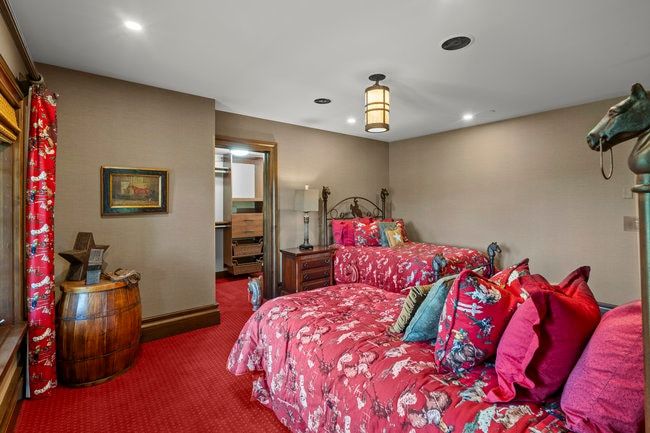 Neutral wall finishes with a red patterned carpet