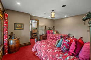 Neutral wall finishes with a red patterned carpet
