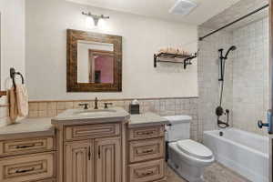 Vanity with distressed wood-finish cabinetry, integrated sink, and dark bronze fixtures