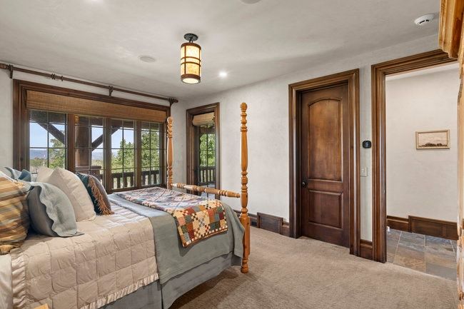 Room featuring a large window expanse with wood trim, a built-in window treatment, and dark wood doors with matching trim