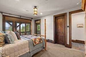 Room featuring a large window expanse with wood trim, a built-in window treatment, and dark wood doors with matching trim