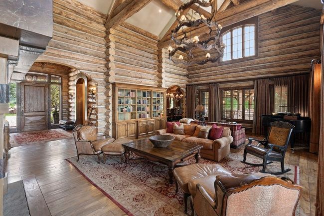 Grand living area featuring exposed log walls and ceiling beams