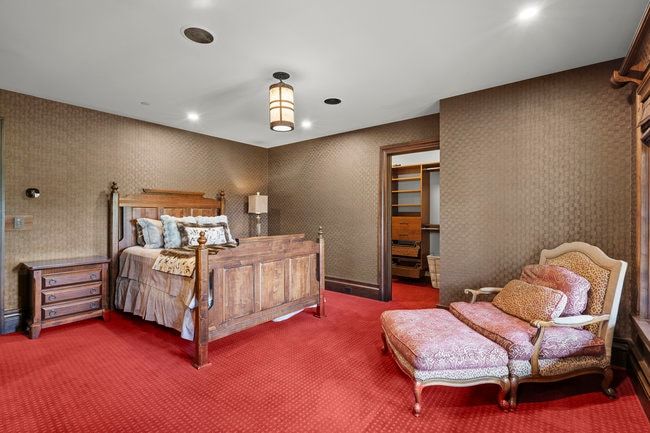Room featuring patterned wall coverings, recessed lighting, and a central decorative light fixture