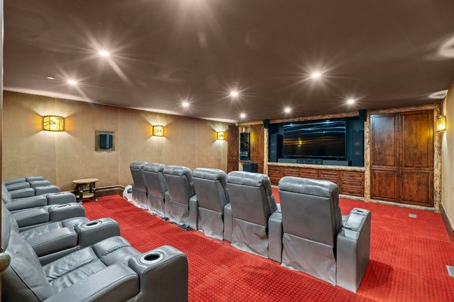 Dedicated media room featuring a large screen display and built-in cabinetry