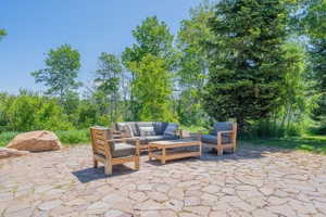 Expansive stone patio featuring irregular flagstone pavers and surrounding mature trees
