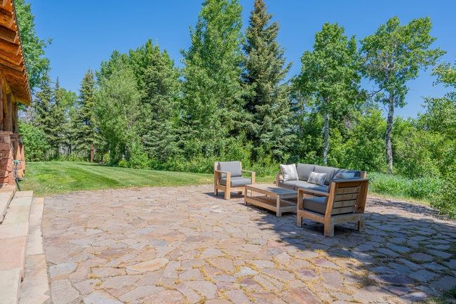 Stone patio with natural-edged flagstone pavers and expansive green space