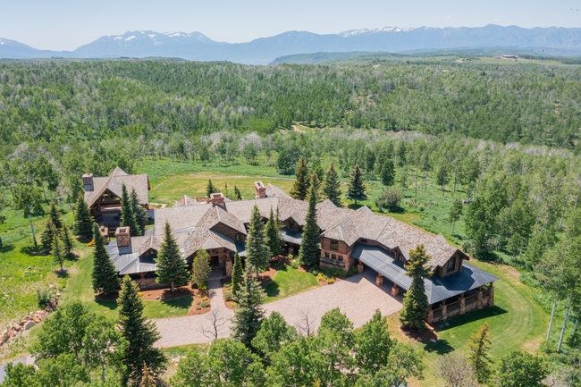Expansive estate featuring multiple structures with natural stone and wood exteriors