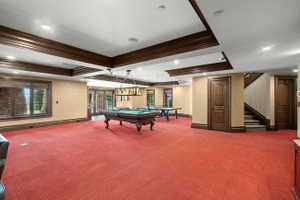 Spacious entertainment area featuring coffered ceilings, recessed lighting, and rich wood trim