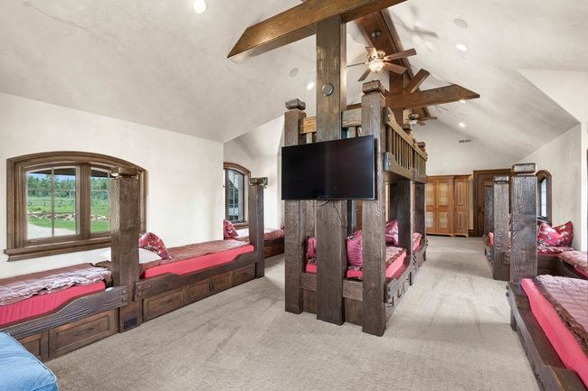 Spacious room featuring multiple custom-built wooden bunk beds with integrated storage drawers