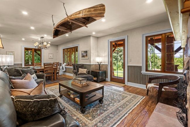 Spacious living area featuring wood-finish flooring, paneled wainscoting, and recessed lighting