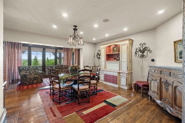 Expansive room featuring wood-finish flooring, recessed lighting, and a multi-pane glass door opening to outdoor scenery