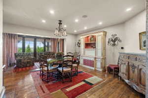 Expansive room featuring wood-finish flooring, recessed lighting, and a multi-pane glass door opening to outdoor scenery