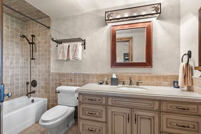 Bathroom featuring a single vanity with stone countertop, integrated sink, and an oil-rubbed bronze faucet