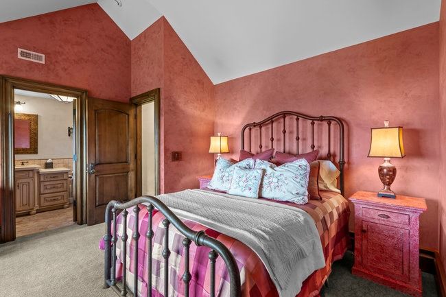 Bedroom with textured red walls and vaulted ceilings