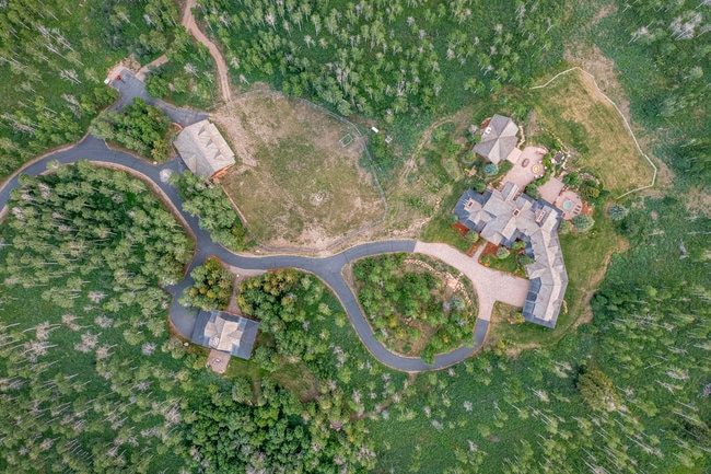 Expansive mountain property featuring a main residence with multiple wings, a secondary structure, and a guest house