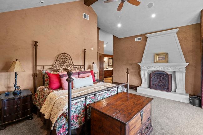 Spacious interior featuring textured wall finishes and a vaulted ceiling with exposed wood beams