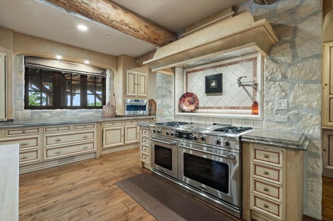 Gourmet kitchen with a professional-grade stainless steel range, double ovens, and a pot filler faucet