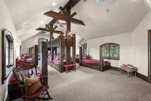 Vaulted ceiling with exposed wood beams, recessed lighting, and ceiling fans