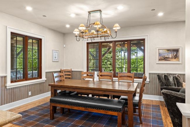 Spacious dining area featuring wood-finish flooring and a plaid area rug