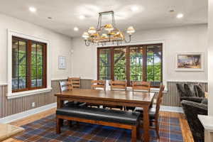 Spacious dining area featuring wood-finish flooring and a plaid area rug