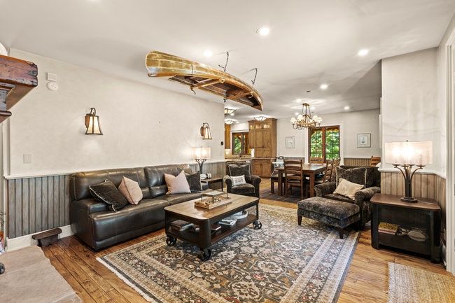 Spacious living area featuring wood-finish flooring, recessed lighting, and wainscoting