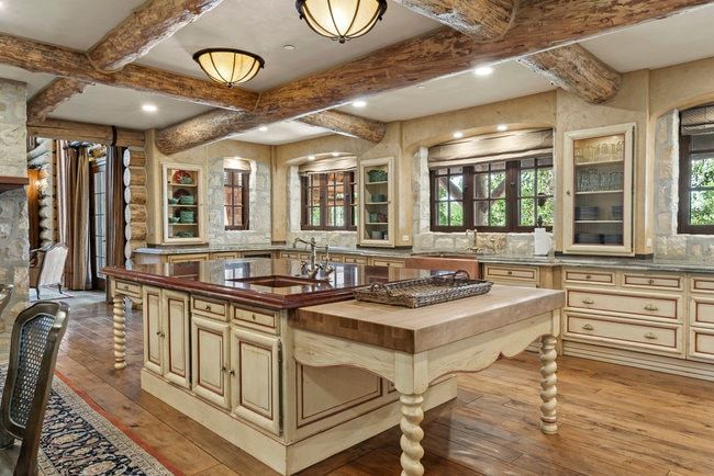 Chef's kitchen featuring exposed log beam ceiling, recessed lighting, and wood-finish flooring