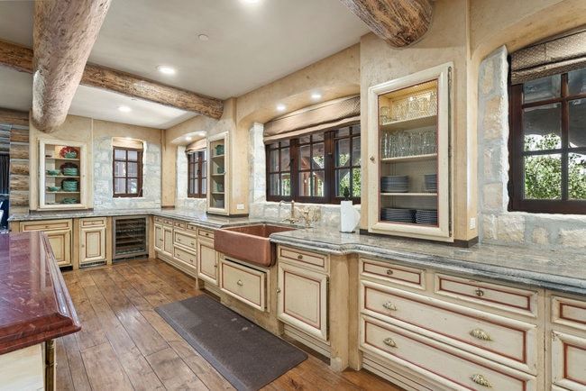 Kitchen featuring wood-finish flooring, exposed wood beams, and stone accent walls