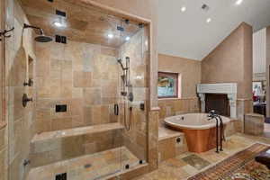 Spacious bathroom featuring a glass-enclosed shower with stone tile, a built-in shower bench, and multiple shower heads