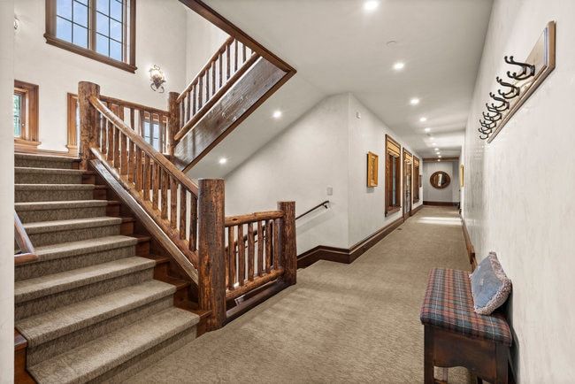 Central staircase featuring rustic wood log newel posts and railings