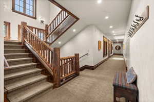 Central staircase featuring rustic wood log newel posts and railings