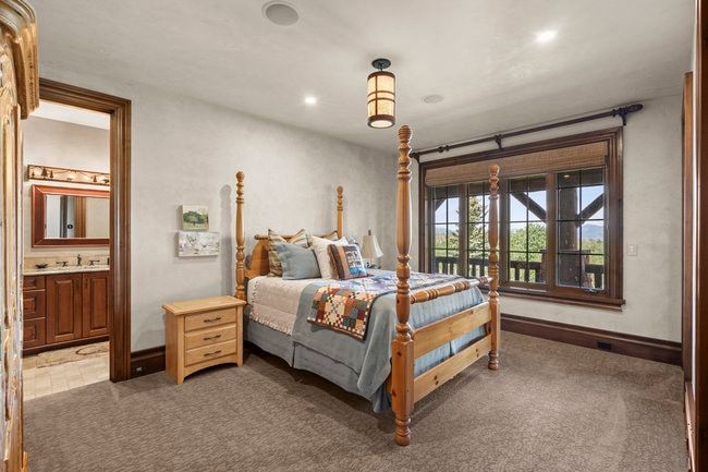 Bedroom featuring a large window with natural wood trim, recessed lighting, a ceiling-mounted light fixture, and carpet flooring