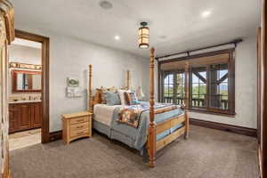 Bedroom featuring a large window with natural wood trim, recessed lighting, a ceiling-mounted light fixture, and carpet flooring