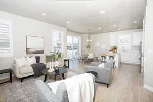 Open-concept living space featuring wood-finish flooring, recessed lighting, and sliding glass door access to the exterior
