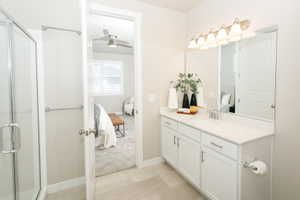 Bathroom vanity featuring a light-toned countertop, dual-basin sink, and ample under-cabinet storage