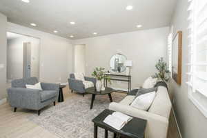Spacious living area featuring recessed lighting, light-toned walls, and wood-finish flooring