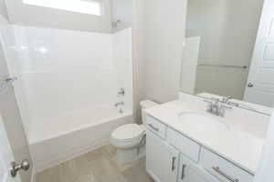 Full bathroom featuring a white vanity with a quartz-finish countertop, undermount sink, and chrome fixtures