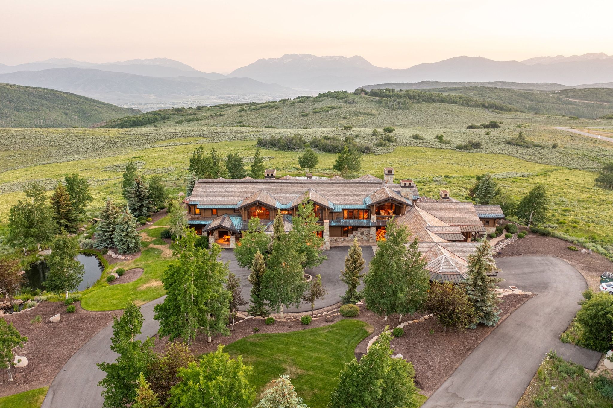 Expansive property featuring a multi-level residence with a wood-shingle roof and stone accents