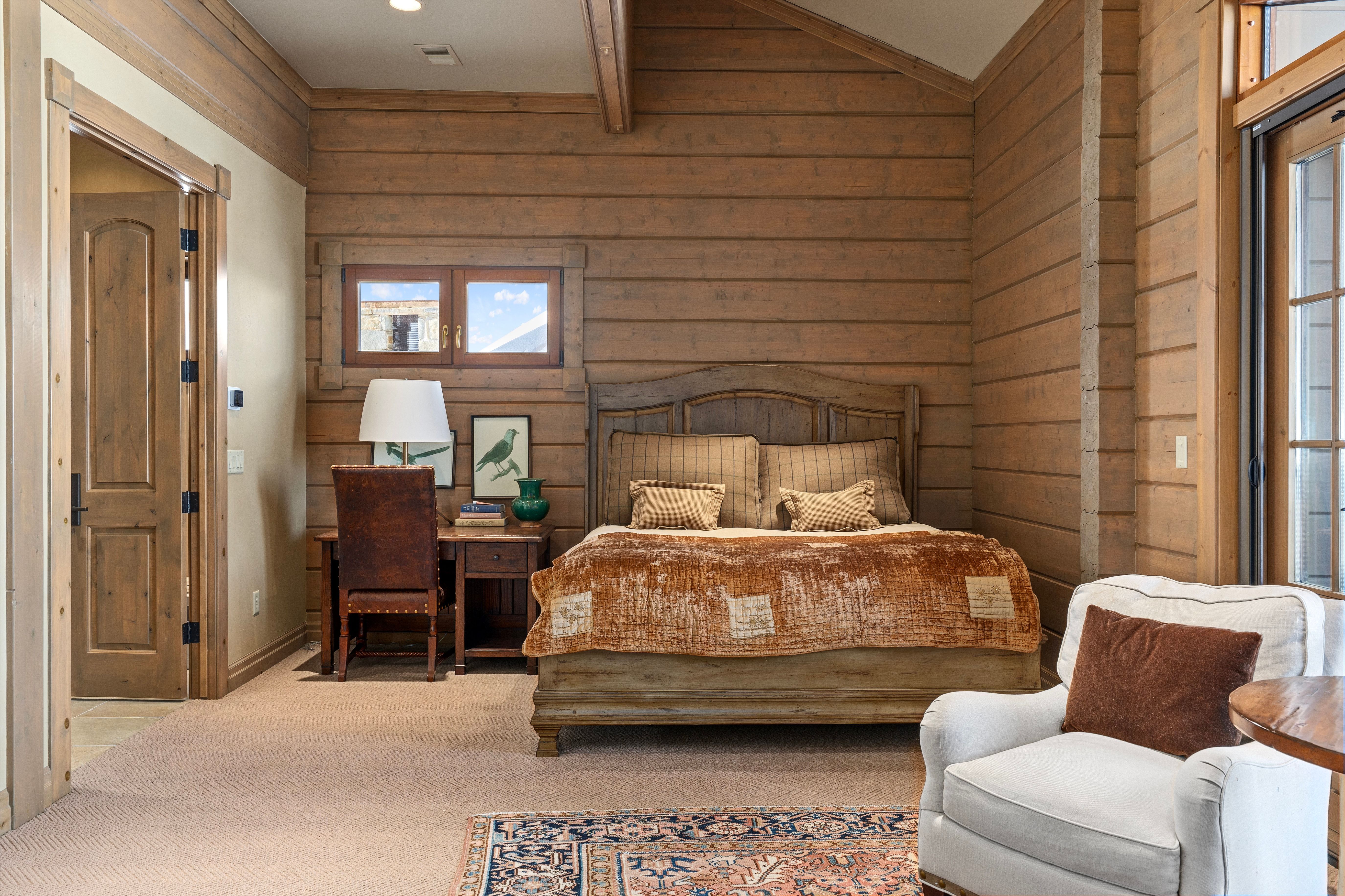 Rustic wood-paneled walls and ceiling beams define this interior space