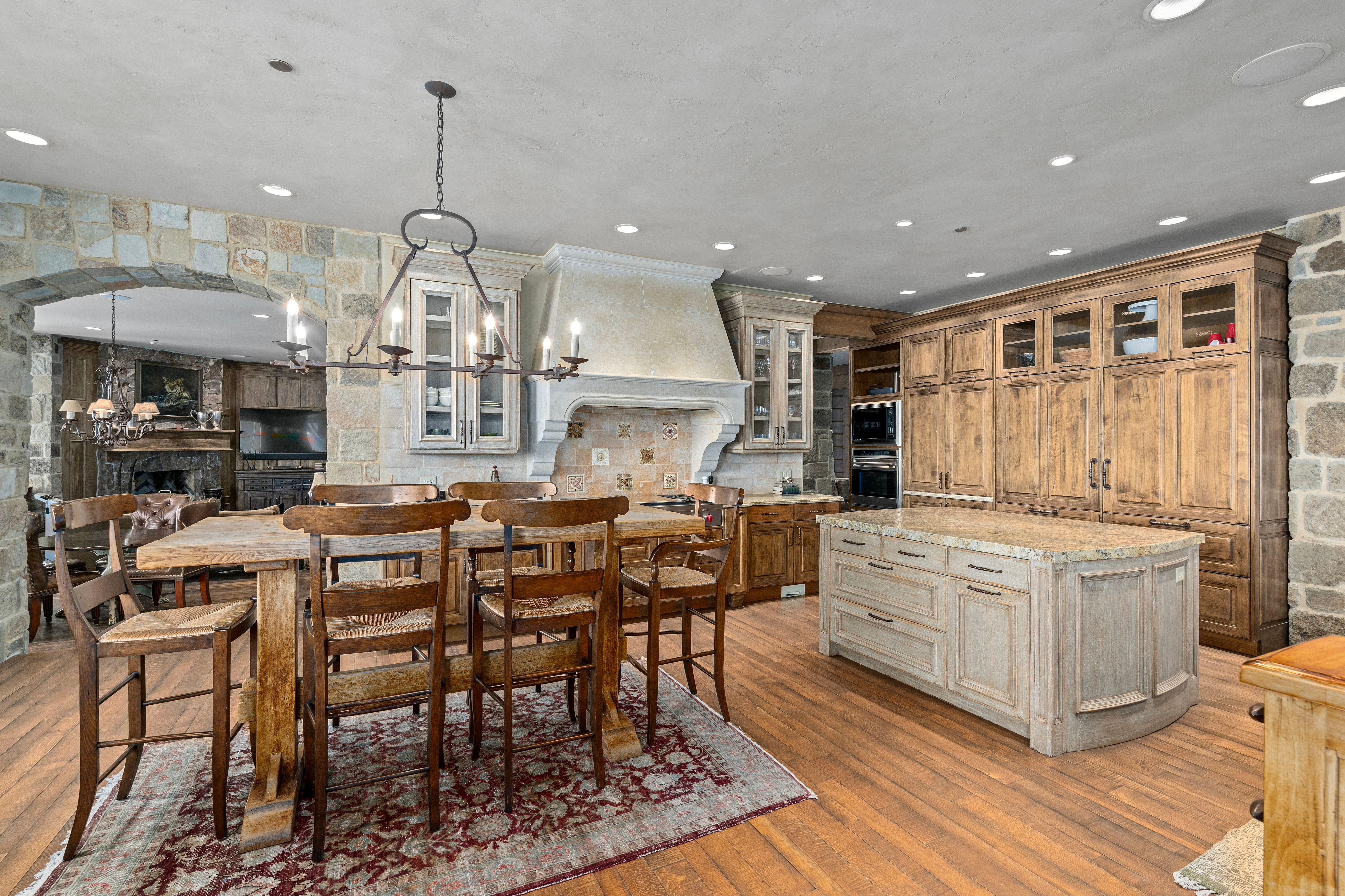 Spacious kitchen featuring stone accent walls and wood-finish flooring