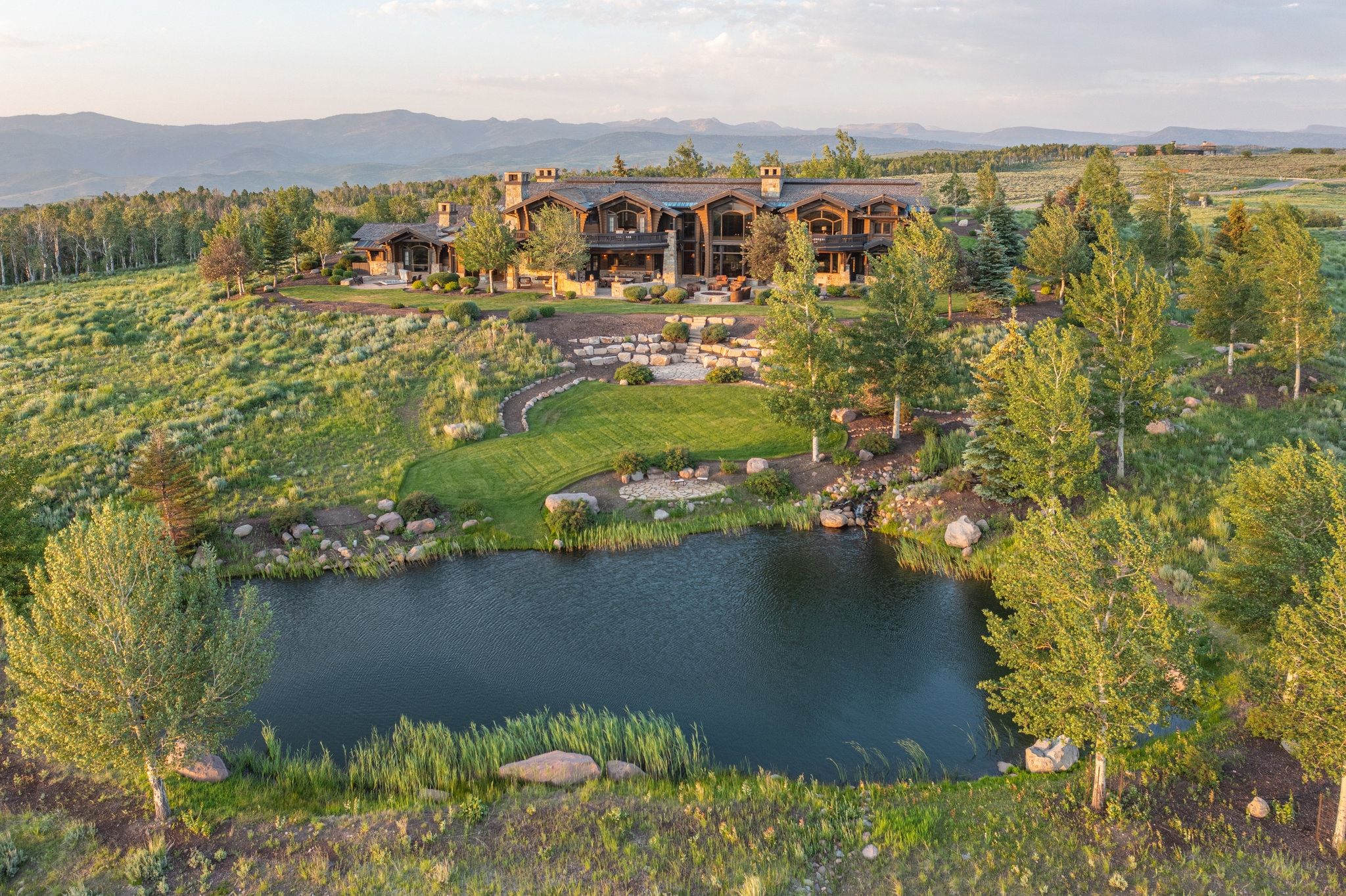 Expansive custom home featuring multiple levels, stone accents, and a prominent chimney