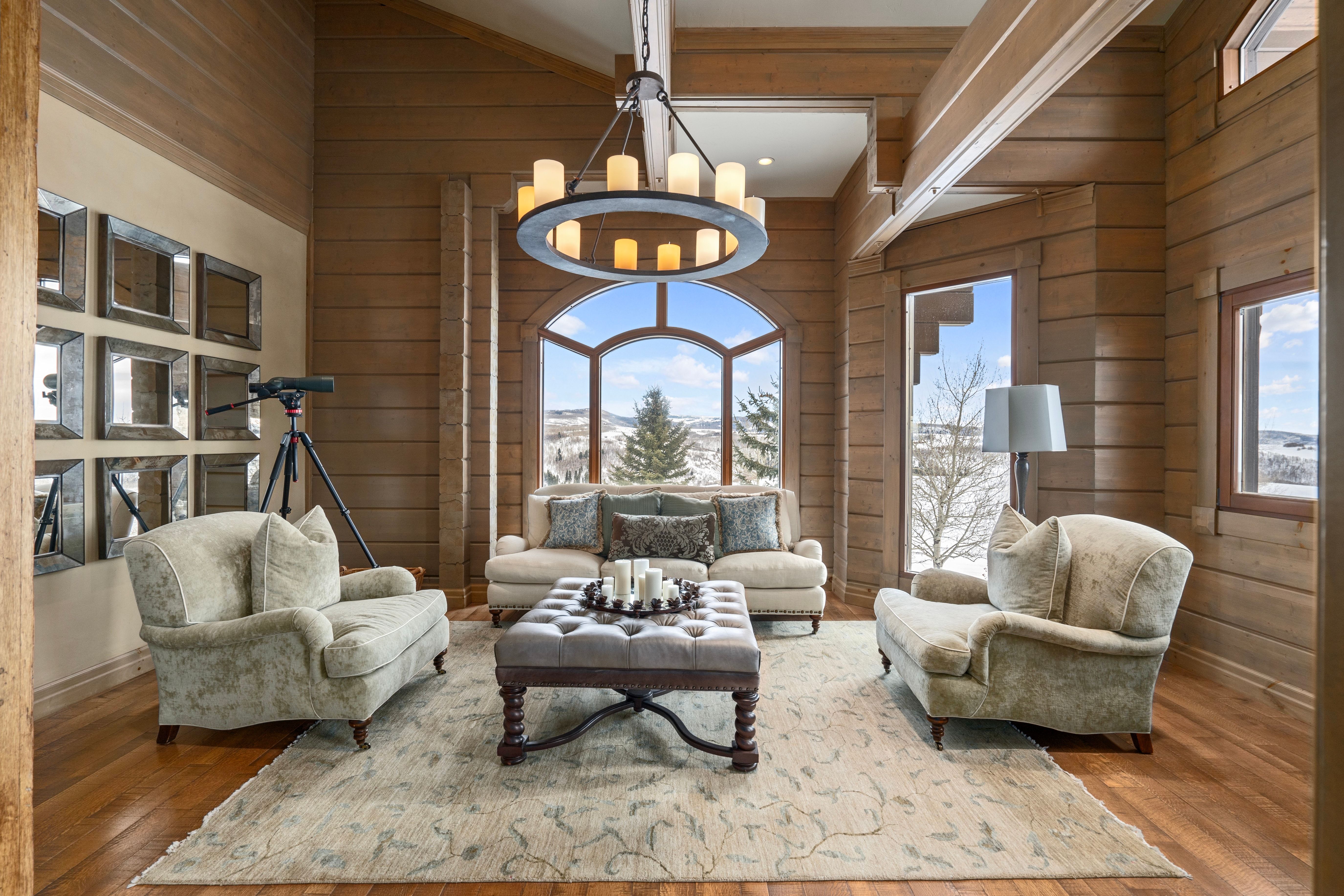 Spacious living area featuring extensive wood-paneled walls and a vaulted ceiling