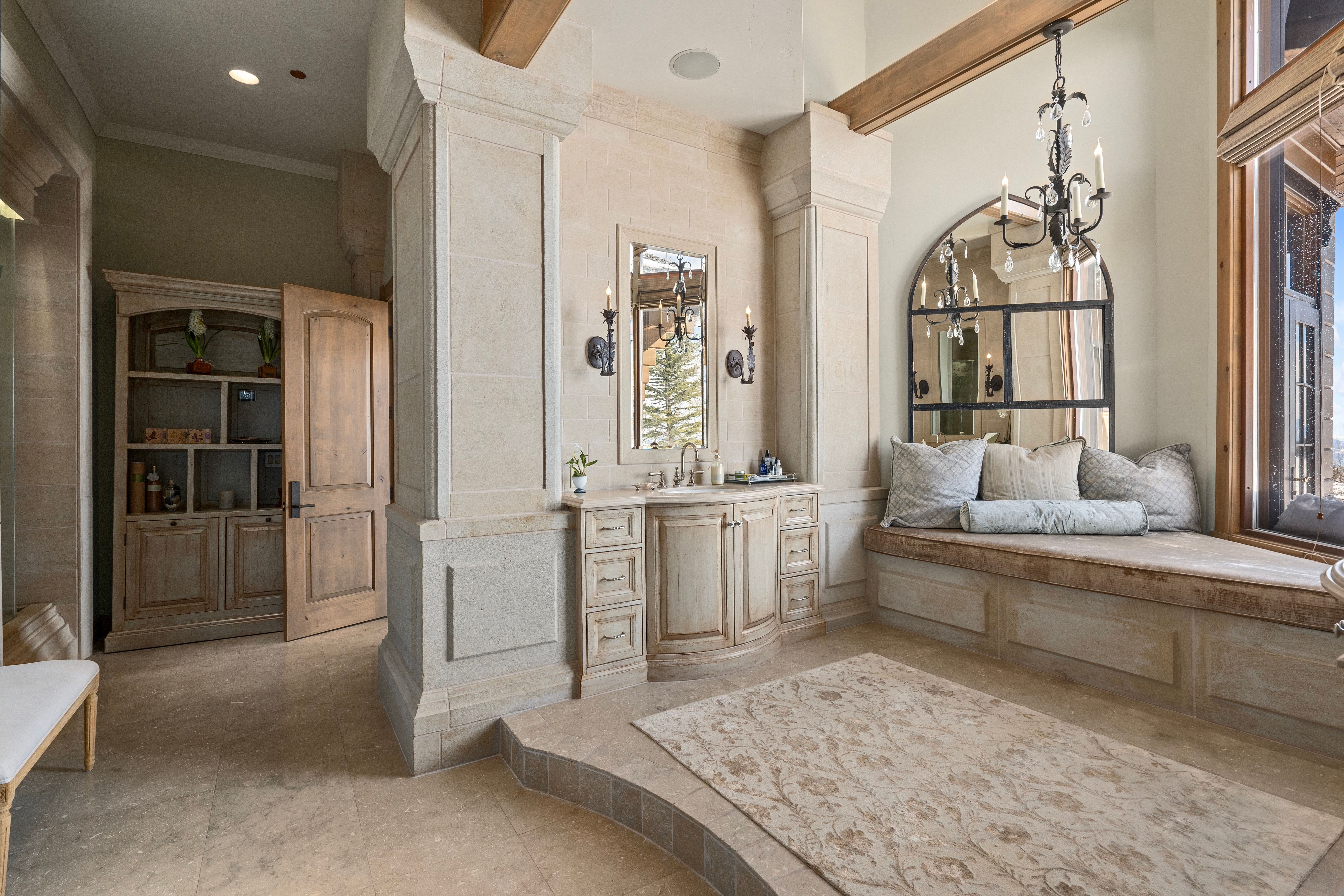 Spacious room featuring light-toned stone flooring and a built-in window bench