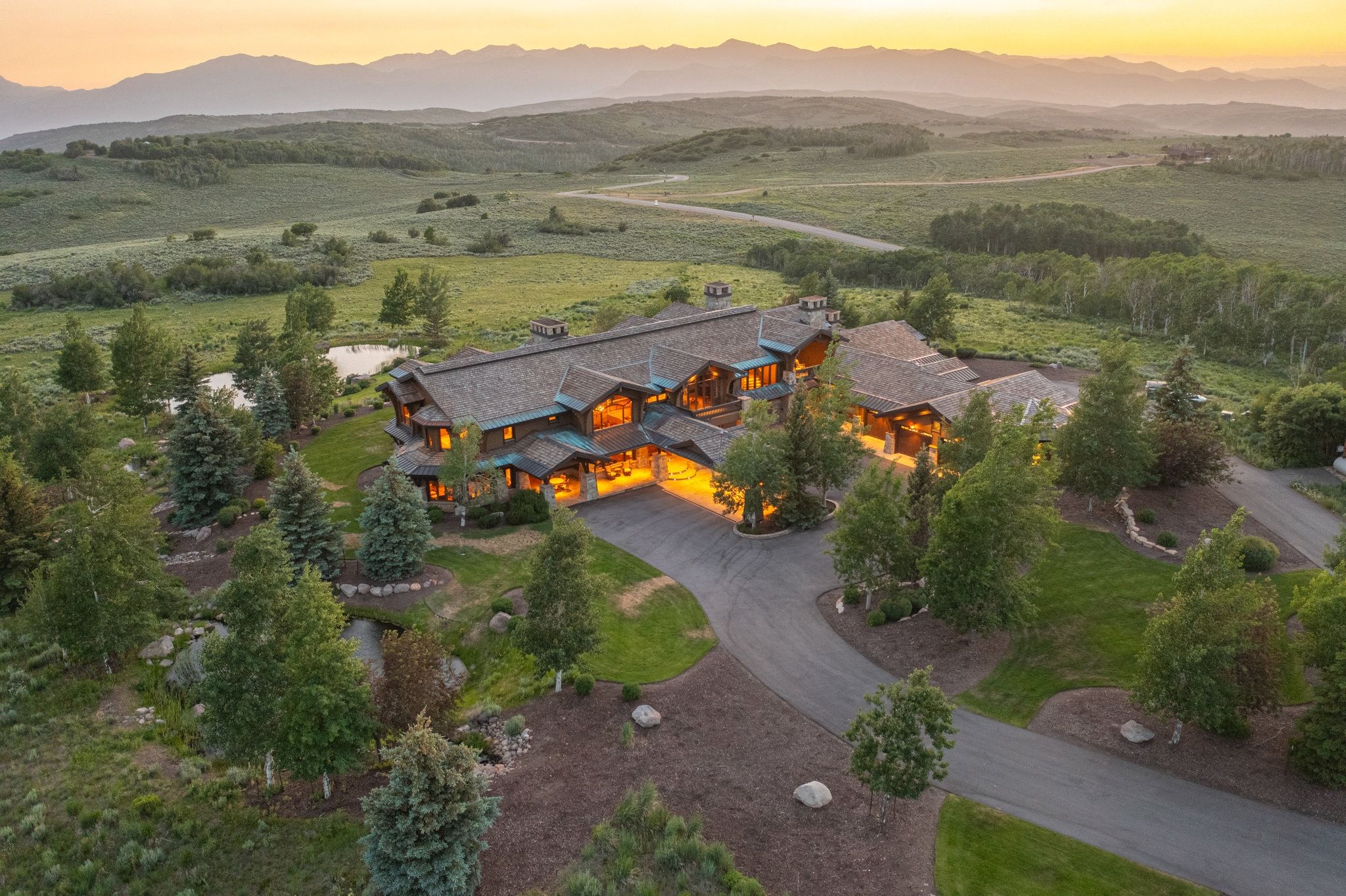 Expansive estate featuring a complex roofline, multiple gables, and a stone and wood exterior