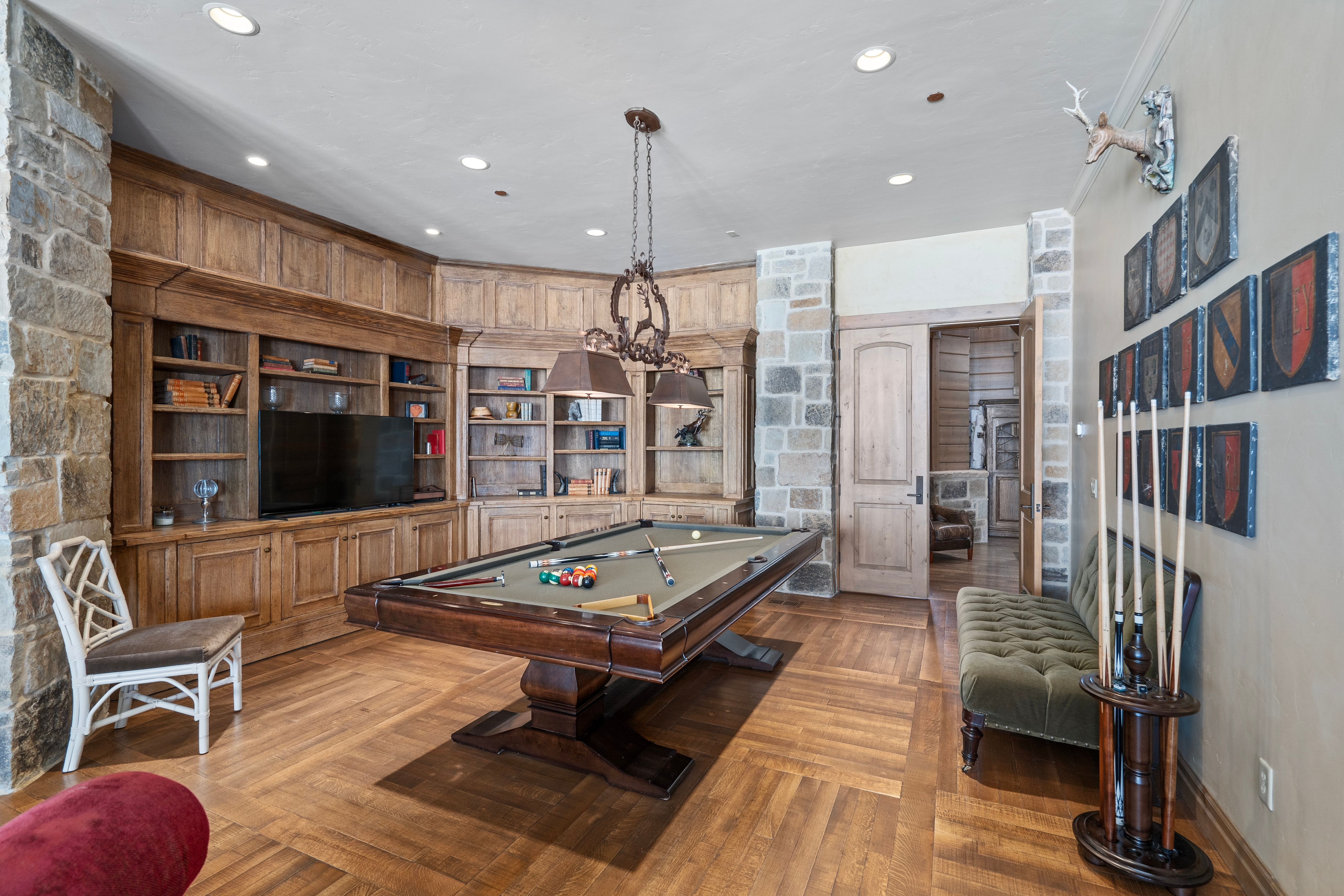 Herringbone wood-finish flooring complements the built-in wood cabinetry and shelving