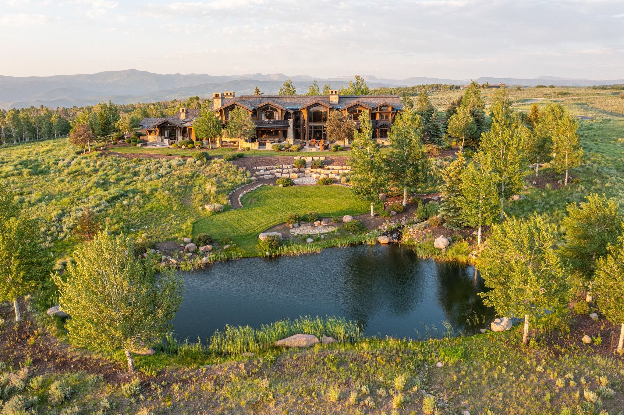 Private pond and manicured lawn complementing the extensive natural landscaping