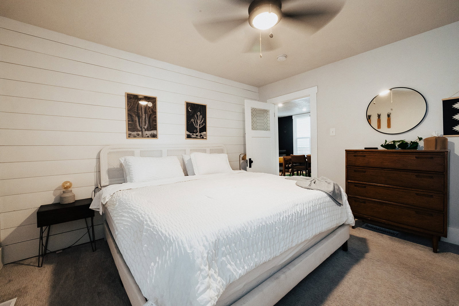 Primary Bedroom featuring a shiplap accent wall, light gray wall paint, and a ceiling fan with integrated lighting